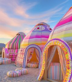 colorfully decorated tents on the beach at sunset