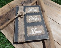 a book that has some writing on it and is sitting in the grass next to a piece of wood