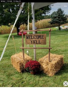 a welcome yall sign sitting on top of hay bales