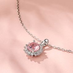 This chic and feminine necklace features a pink morganite surrounded by a sparkling halo of vibrant, bright white and very well cut white stones. The morganite is a beautiful blush color reminiscent of rosé, and its well executed round cut displays gorgeous sparkle. The effect is an air of timeless luxury and modern elegance! Whether you are buying for yourself or a special someone, this necklace is sure to impress!Carat Weight: 1.25 ctStone Size: 7 mmNumber of Stones: 1 Stone Shape: RoundStone Feminine Pink Pendant Jewelry, Exquisite Pink Pendant Necklace, Elegant Blush Necklace For Gift, Formal Pink Pendant Jewelry, Dazzling Pink Gemstone Jewelry, Pink Round Cut Halo Setting Jewelry, Feminine Pink Sterling Silver Necklaces, Dazzling Pink Jewelry With Halo Setting, Pink Jewelry With Round Diamond Accents