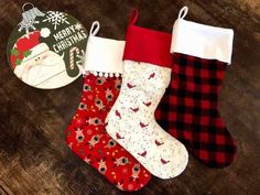 three christmas stockings sitting on top of a wooden table