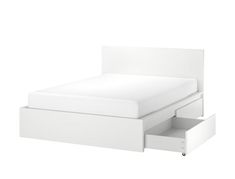 a white bed with two drawers underneath it