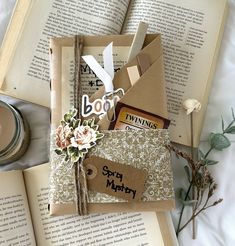 an open book sitting on top of a table next to some flowers and other items