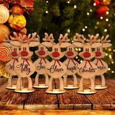 three wooden reindeer figurines on a table with christmas decorations and lights in the background