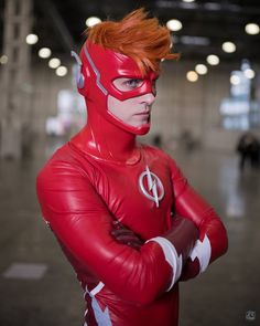 a man dressed as the flash poses for a photo