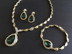 "** This necklace comes with a matching bracelet together with a pair of earrings (studs at back design). ** Featuring lovely teardrop shaped pendants embellished with clear rhinestones crystals and green glass stones on top. Great to wear on your wedding day or party event!! Color: gold plated with clear rhinestone crystals and green glass stones Size: necklace measures around 19\" long x center 2\" drop x 1\" width, bracelet 8.5\" long x 0.75\" width and earrings 1.35\" long x 0.75\" width ** Emerald Teardrop Pendant For Wedding, Wedding Teardrop Emerald Pendant Jewelry, Wedding Emerald Teardrop Pendant Jewelry, Emerald Necklace Set, Green Emerald Necklace, Jewelry Prom, Block Print Scarf, Shoulder Necklace, Wedding Jewelry Set