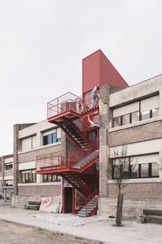 a red fire hydrant in front of a building with stairs leading up to it