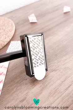 a close up of an object on a wooden floor with paper clips stuck to it