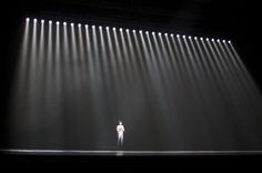 a man standing on top of a stage under spotlights