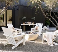 an outdoor fire pit surrounded by chairs and tables