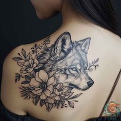 the back of a woman's shoulder with a wolf and flowers tattoo on it