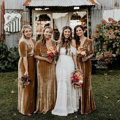 four bridesmaids in velvet dresses posing for a photo