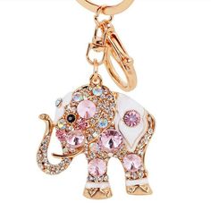 an elephant keychain with pink and white crystals on the front, in gold tone