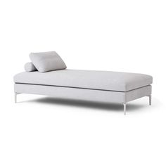 a white chaise lounger with two pillows on it