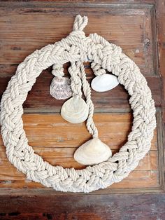 a rope and seashells hanging on a wooden wall