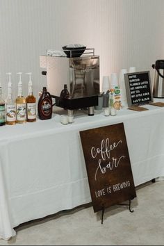 a table topped with bottles of alcohol and a sign that says coffee bar love is brewing