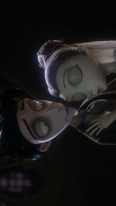 two animated dolls in the dark with their mouths open and eyes closed, looking at each other