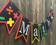 a colorful banner that says math hangs on a wooden fence next to a brown fence