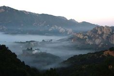 the mountains are covered in fog and low lying clouds