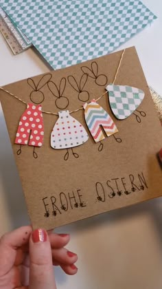 someone is holding up a card with some clothes hanging from it's sides and the words, frohe ostern