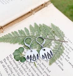 Rustic Tree Earrings, Nature Tree Dangle Earrings, Hypoallergenic Ear Jewelry, Forest Jewelry, Nature Lover Gift, Hiker Gifts, Outdoors Gift Rustic tree earrings!! Great gift idea for nature lovers, hikers, campers, forest rangers, mountain lovers and much more!! These earrings are made with round silver aluminum charms metal stamped with 3 different tree types (4 total trees) on each one. They are attached to stainless steel lever back ear wires.  These earrings are extremely lightweight and ar Nature-inspired Dangle Hoop Earrings As Gift, Nature-inspired Dangle Hoop Earrings For Gift, Nickel-free Nature-inspired Earrings As Gift, Nature-inspired Dangle Hoop Earrings, Nickel-free Nature-inspired Earrings For Gift, Nature-inspired Hoop Earrings As Gift, Nature-inspired Round Hoop Earrings For Gift, Adjustable Personalized Earrings As Gift, Personalized Adjustable Earrings For Gift