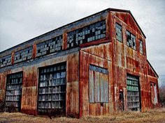 an old rusted building with windows and doors