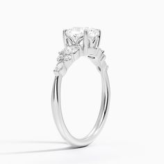 Cushion Cut Nadia Three Stone Engagement Engagement Ring - Platinum. This three stone ring features a dazzling cluster of round and marquise-shaped diamonds that rest upon the shoulders of the gently tapered band. The center gem is held by four claw prongs as it sits upon a slightly open gallery (2/5 total carat weight). Anniversary Marquise Lab Grown Diamond Ring, Dazzling Moissanite Marquise Cut Diamond Ring, Marquise Moissanite Wedding Ring With Diamond Accents, Dazzling Marquise-cut Platinum Wedding Ring, Marquise Moissanite Diamond Ring With Prong Setting, Lab Grown Diamond Wedding Ring With Marquise Cut, Marquise Cut Lab Grown Diamond Wedding Ring, Marquise Cut Lab Grown Diamond Wedding Ring With Accents, Marquise Cut Lab Grown Diamond Ring With Accents