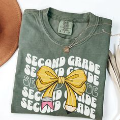 Embrace the back-to-school spirit with our trendy Comfort Colors Second Grade Teacher Shirt, perfect for elementary school teaching! This 2nd Grade Teacher T-Shirt makes an ideal gift for new teachers, uniting the teacher team in style. UNISEX SIZING, relaxed fit. Not a Women's size, please refer to the size chart for more details. HOW TO ORDER: 1. Review all photos. 2. Select size and color from drop down menu.  3. Add to cart, and repeat 1, 2 and 3 for additional items.  PROCESSING AND SHIPPIN Preppy Cotton T-shirt With Letter Print, Preppy Cotton Tops With Letter Print, Back To School Letter Print T-shirt, Pre-shrunk T-shirt For Back To School, School Spirit Tops With Screen Print, School Spirit Screen Print Tops, Back To School Letter Print Tops For School Events, Text Print Tops For Back To School, School Spirit T-shirt For College And Back To School