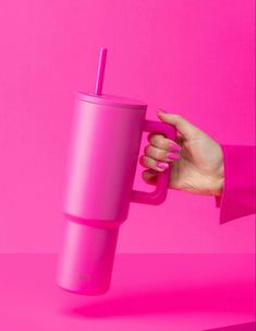 a woman's hand holding a pink tumbler cup