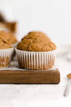 two muffins sitting on top of a wooden cutting board