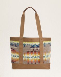 Elevate your travels or daily commute with our Highland Peak Zip Tote. Designed with a roomy zip-top and crafted with wool jacquard from our Pacific Northwest mills, this tote exudes distinctive style. The polyester canvas trim and leather handles add a touch of luxury, while the interior slip pocket provides practicality. Each piece is unique with varying pattern placements, making it truly one-of-a-kind. Loving the Highland Peak Design? Check out the matching backpack & crossbody bag. Highland Fall Travel Shoulder Bag With Leather Trim, Wool Tote Bag For Travel, Wool Travel Bags For Fall, Fall Canvas Shoulder Bag With Leather Handles, Fall Travel Bags With Leather Trim, Fall Canvas Bag With Leather Trim, Fall Canvas Bags With Leather Trim, Leather Trim Tote Shoulder Bag For Overnight Trips, Pendleton Bag