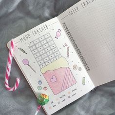 an open planner book with candy canes and candies on the cover, next to a pink striped lollipop