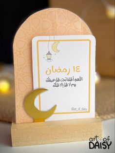 an arabic greeting card with the moon and crescent on it's stand in front of some candles