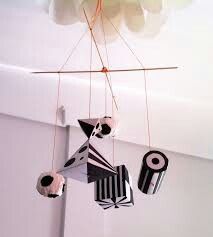 a mobile made out of black and white paper hanging from the ceiling in a room