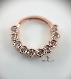 a rose gold ring with clear stones on it