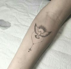 a small tattoo on the arm of a woman with a bird flying above her head