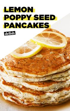 a stack of lemon poppy seed pancakes on top of a white plate with sliced lemons