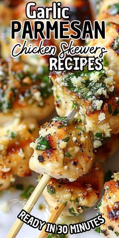 grilled chicken skewers with parmesan cheese and herbs are on a white plate