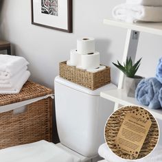 a white toilet sitting next to a shelf filled with towels and other bathroom items on top of it