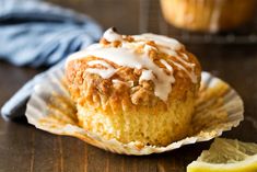 a close up of a muffin with icing on it and a lemon wedge