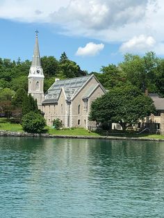 an old church sits on the shore of a lake