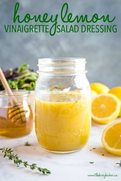 honey lemon vinaigrete salad dressing in a mason jar with fresh herbs around it