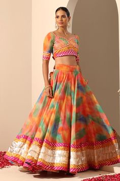 Orange lehenga with multi colored abstract patterns, lampi and gota patti border with side tassels. Comes with matching gota patti blouse with back tassel and dupatta.
Components: 3
Neckline: Sweetheart
Sleeve Type: Elbow
Fabric: Lehenga and Blouse: Georgette, Dupatta: Soft Net
Color: Orange
Other Details: 
Length:
Lehenga: 40 inches
Dupatta: 2.5 mtrs
Dupatta width: 44 inches
Note: Potli bag held by the model is not for sale
Occasion: Destination Wedding - Aza Fashions Fusion Style Multicolor Lehenga With Cutdana, Fusion Style Multicolor Cutdana Lehenga, Multicolor Lehenga For Diwali Party, Fusion Style Multicolor Sets With Cutdana, Fusion Style Multicolor Cutdana Sets, Multicolor Party Lehenga For Diwali, Fusion Multicolor Sets With Cutdana, Fusion Multicolor Cutdana Sets, Diwali Party Multicolor Lehenga