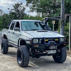 a white truck parked on top of a dirt road