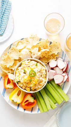 a plate with chips, celery, radishes and other food on it