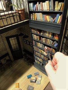 a person holding a pen in front of a bookshelf filled with lots of books