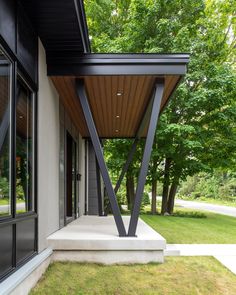 an outdoor covered patio with grass and trees in the background