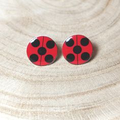 pair of red and black ladybug earrings on wood