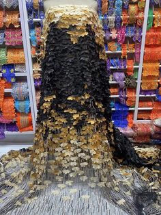 a mannequin is covered in gold and black sequins at a store