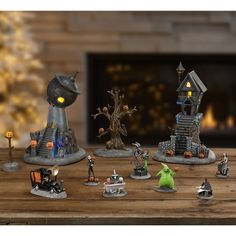 a group of figurines sitting on top of a wooden table next to a fireplace